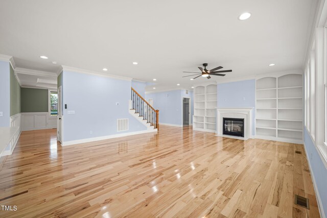 2804 Jack Mitchell Rd, Zebulon, NC 27597 - unfurnished living room featuring visible vents, light wood finished floors, stairs, ceiling fan, and built in shelves