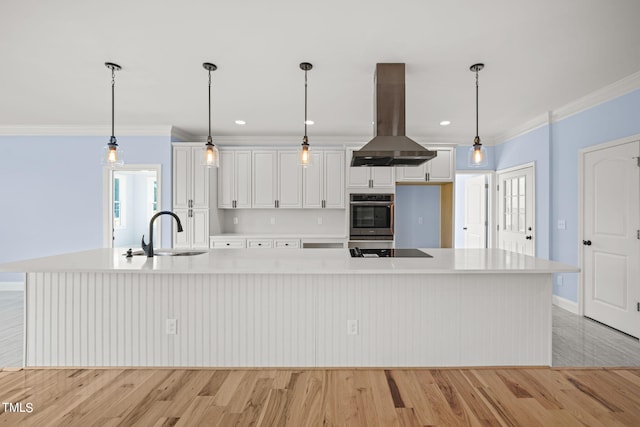 kitchen featuring decorative light fixtures, white cabinets, a spacious island, and island range hood