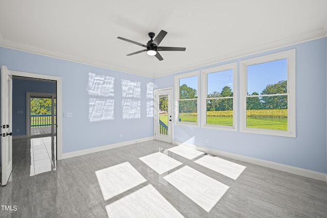 empty room featuring a wealth of natural light, ceiling fan, ornamental molding, and hardwood / wood-style floors