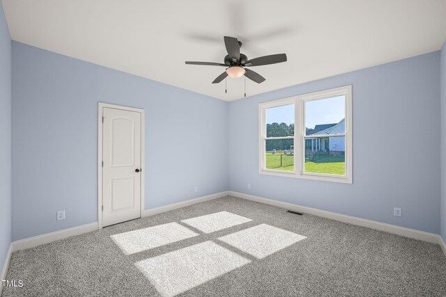 carpeted spare room featuring ceiling fan