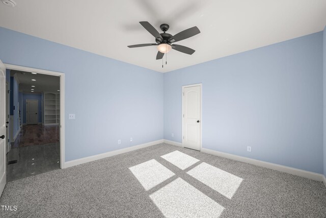 carpeted spare room featuring ceiling fan