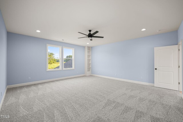 unfurnished room with ceiling fan and carpet