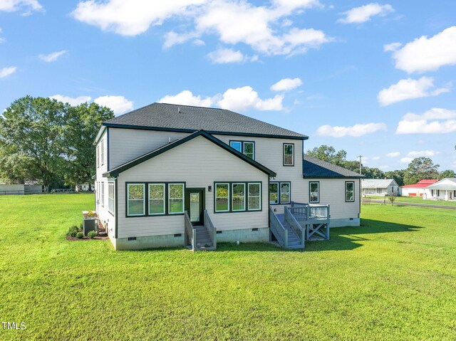 rear view of house featuring central air condition unit and a yard