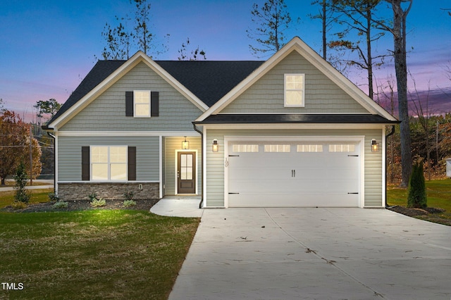 craftsman-style house featuring a garage and a yard