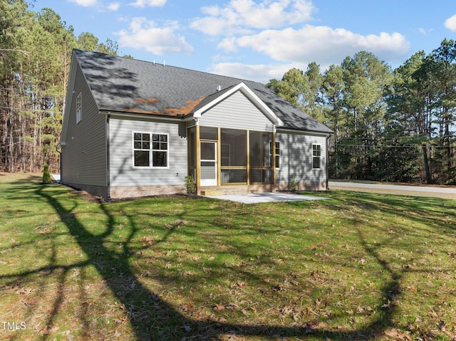 rear view of property with a sunroom, a patio area, and a yard