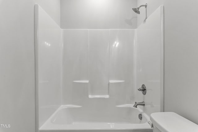 bathroom with shower / bathing tub combination and toilet