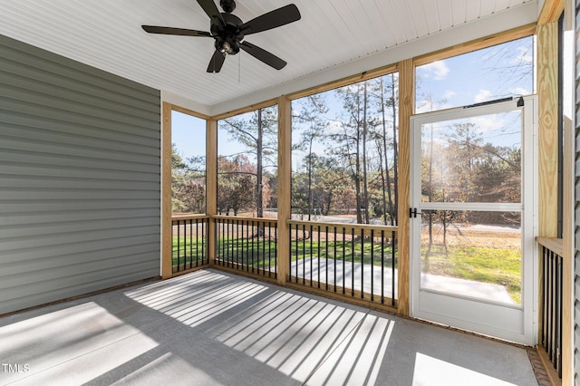 unfurnished sunroom featuring ceiling fan and a wealth of natural light