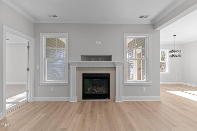 unfurnished living room with light wood-type flooring, ornamental molding, and a chandelier