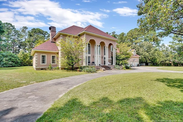 mediterranean / spanish home with a garage, a front yard, and covered porch