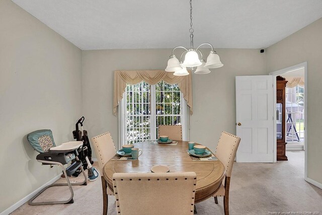 carpeted dining space with plenty of natural light and an inviting chandelier