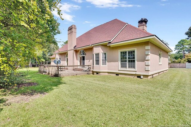 rear view of property featuring a lawn and a wooden deck