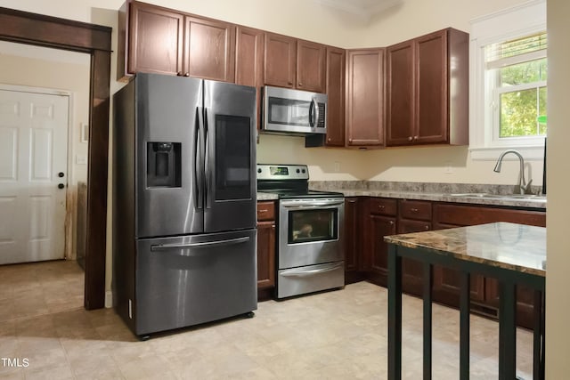 kitchen featuring a sink, stainless steel appliances, and light stone countertops