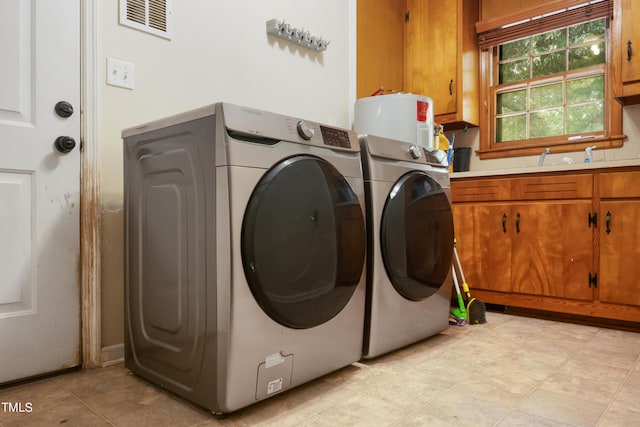 laundry room with washer and dryer, visible vents, and cabinet space