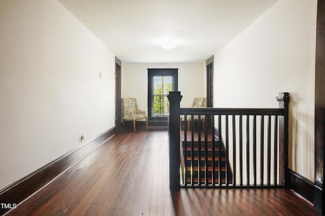 interior space featuring an upstairs landing, baseboards, and wood-type flooring