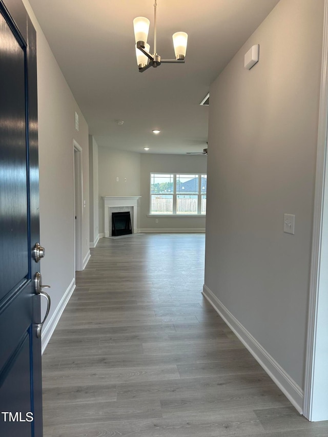 corridor with a chandelier and hardwood / wood-style floors