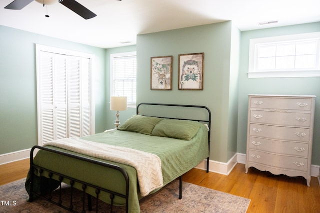 bedroom featuring wood-type flooring, ceiling fan, and a closet