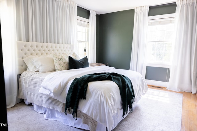 bedroom featuring light wood-type flooring and multiple windows