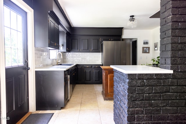 kitchen featuring appliances with stainless steel finishes, a wealth of natural light, light tile patterned floors, and sink