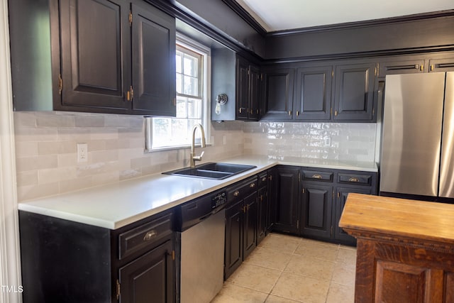 kitchen featuring stainless steel appliances, sink, light tile patterned floors, and tasteful backsplash