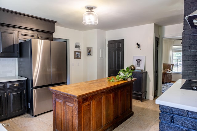 kitchen with a center island, stainless steel refrigerator, and light tile patterned flooring