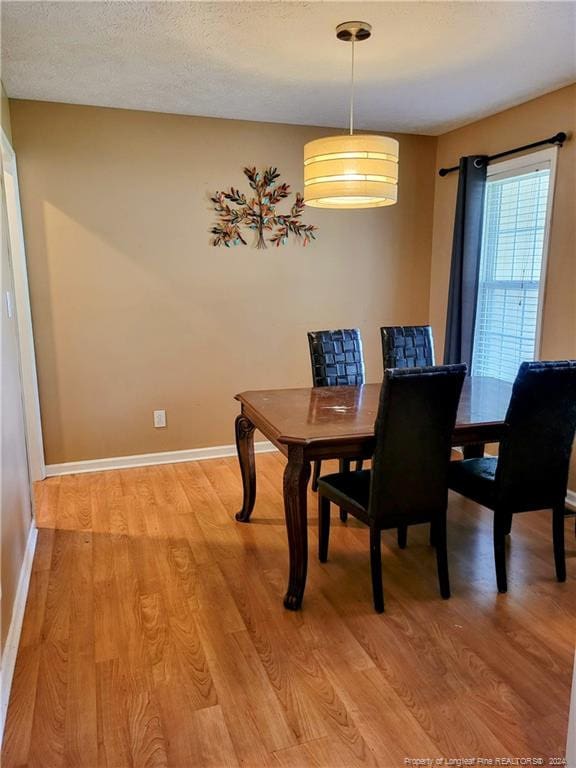 dining area featuring light hardwood / wood-style floors and a textured ceiling