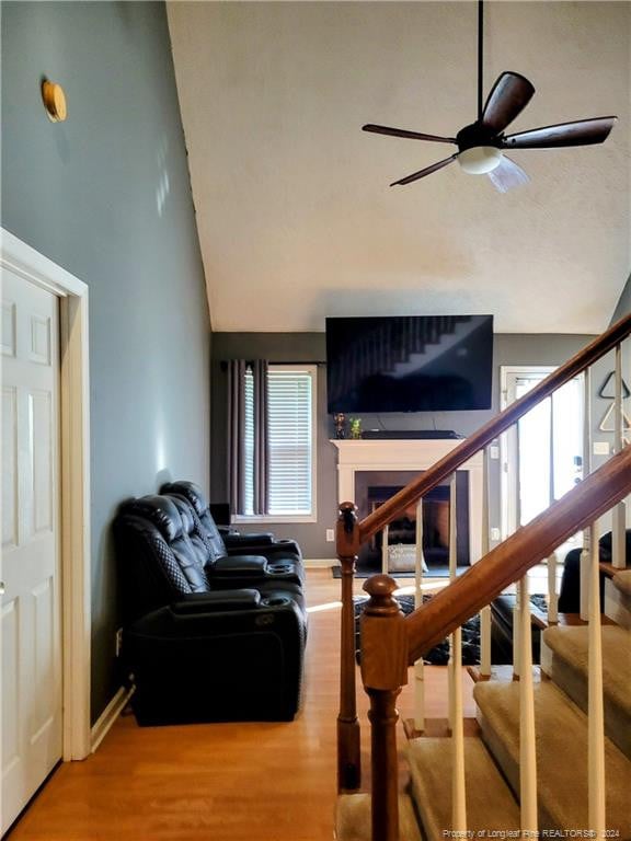 living room with high vaulted ceiling, ceiling fan, and hardwood / wood-style flooring