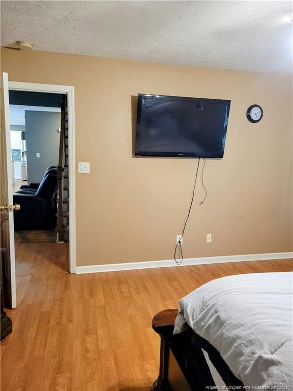 bedroom featuring light wood-type flooring and a textured ceiling