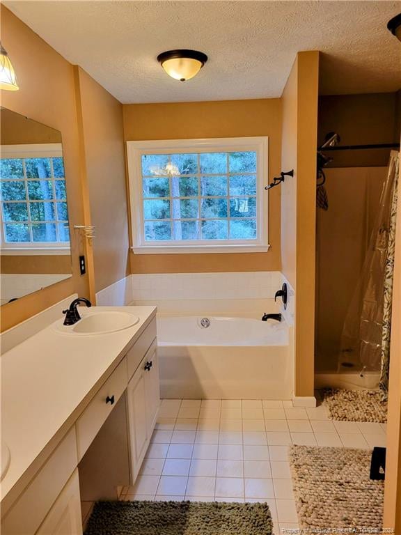 bathroom featuring vanity, a textured ceiling, plus walk in shower, and tile patterned flooring