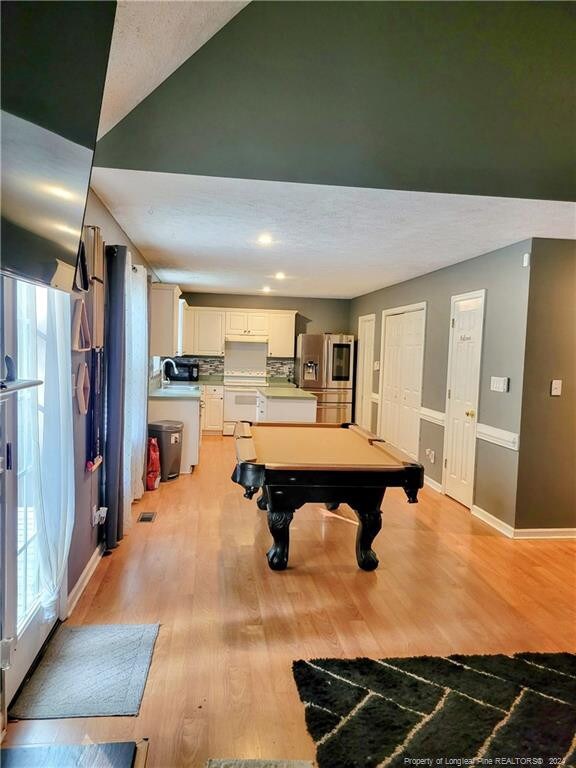 playroom featuring pool table, sink, and light hardwood / wood-style flooring