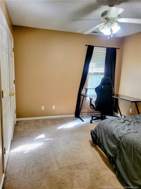 bedroom with light carpet and ceiling fan