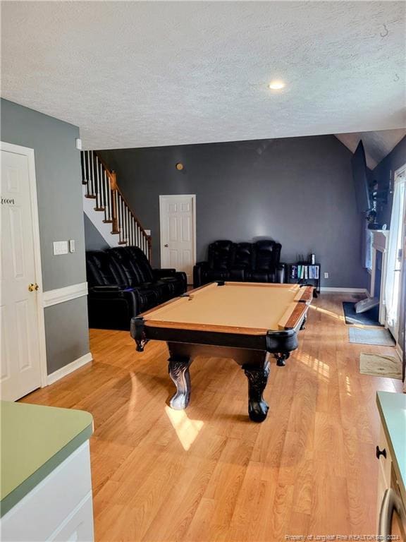 playroom featuring pool table, a textured ceiling, and light hardwood / wood-style flooring