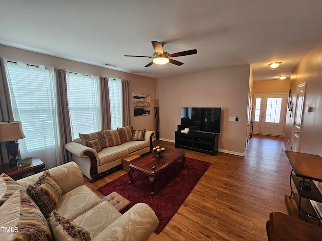 living room featuring ceiling fan and dark hardwood / wood-style floors