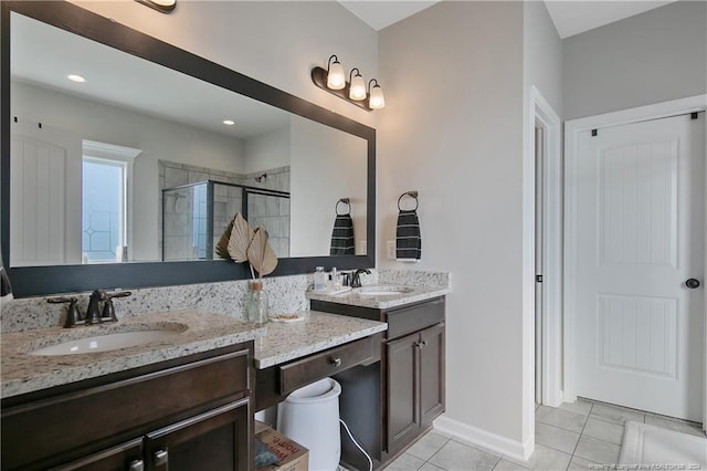 bathroom featuring tile patterned flooring, an enclosed shower, and vanity