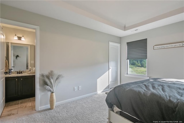 bedroom featuring light carpet, connected bathroom, and sink