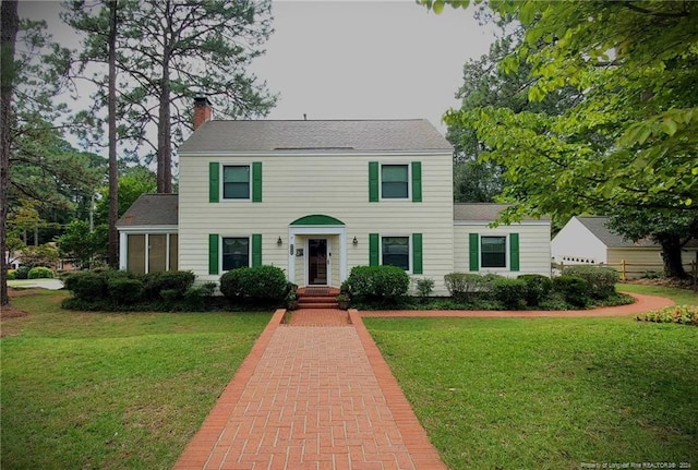 colonial-style house featuring a front yard