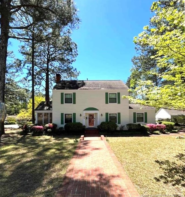 colonial home featuring a front lawn