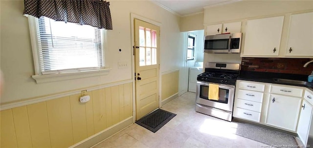 kitchen with white cabinetry, sink, ornamental molding, and appliances with stainless steel finishes