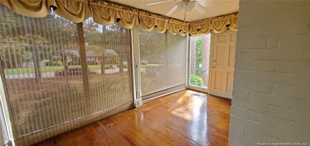 unfurnished sunroom with ceiling fan