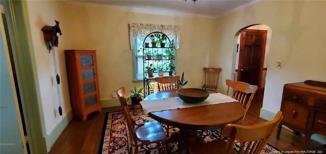 dining room with dark hardwood / wood-style flooring and crown molding