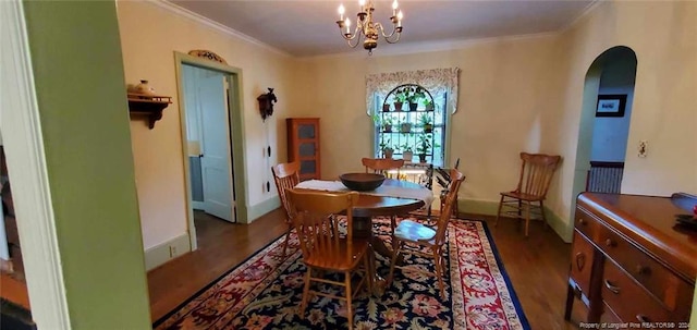 dining space featuring dark hardwood / wood-style floors, an inviting chandelier, and crown molding