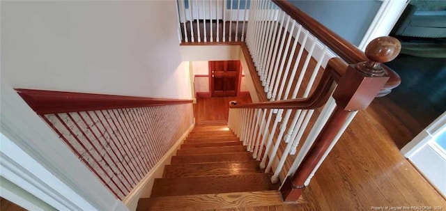 stairs featuring wood-type flooring and a towering ceiling