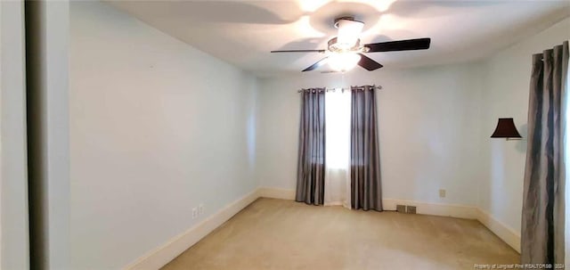 carpeted spare room featuring ceiling fan