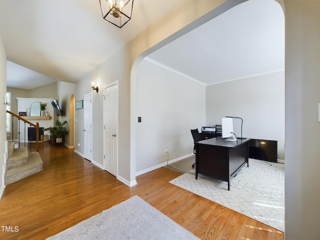 office space featuring ornamental molding, wood-type flooring, and a notable chandelier