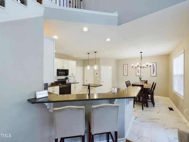 kitchen with hanging light fixtures, kitchen peninsula, a kitchen bar, and stainless steel range with electric cooktop