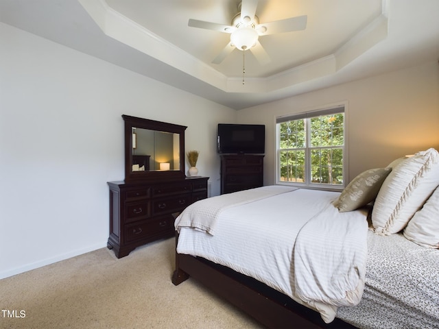 bedroom with light carpet, a raised ceiling, crown molding, and ceiling fan