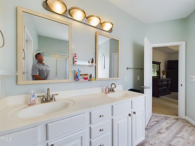 bathroom with a shower with door, vanity, and wood-type flooring