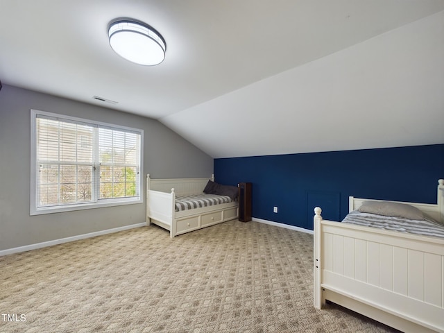 bedroom with light colored carpet and vaulted ceiling