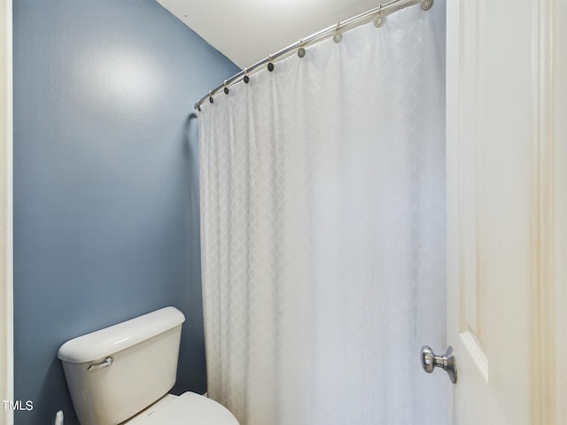 bathroom featuring toilet and a shower with curtain