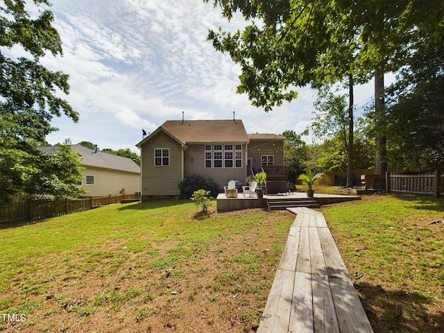 rear view of property with a yard and a deck