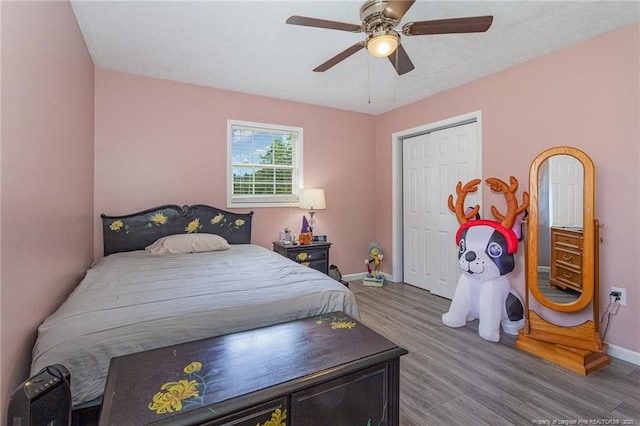 bedroom with hardwood / wood-style flooring, a closet, and ceiling fan